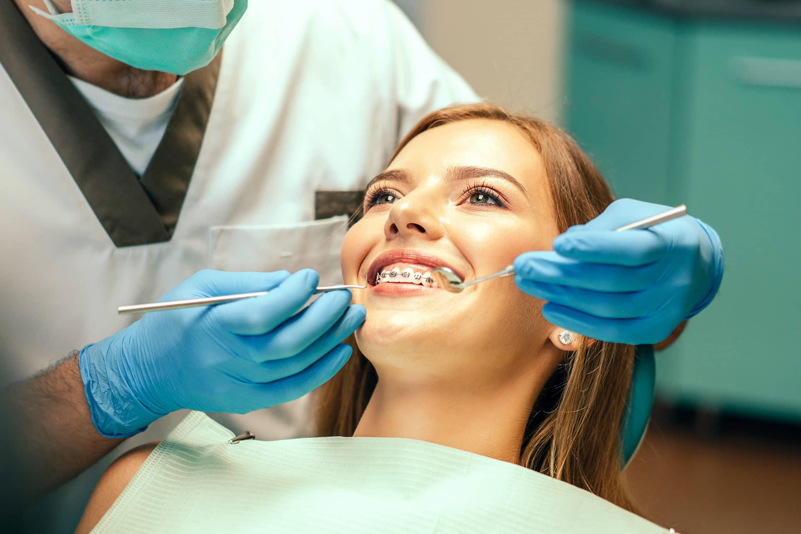 a woman getting her braces checked by her orthodontist