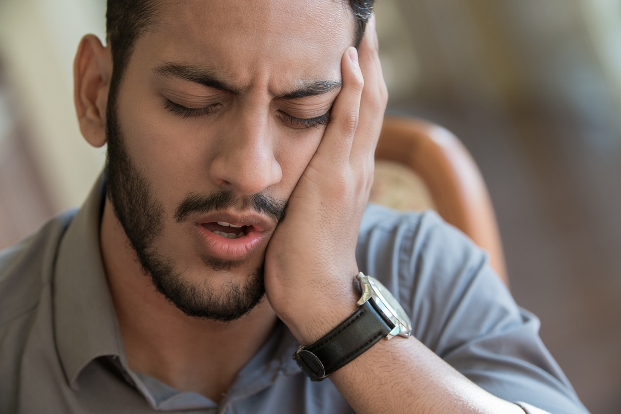 Man holding his cheek in pain as he waits to receive emergency orthodontic treatment in Clovis, CA.