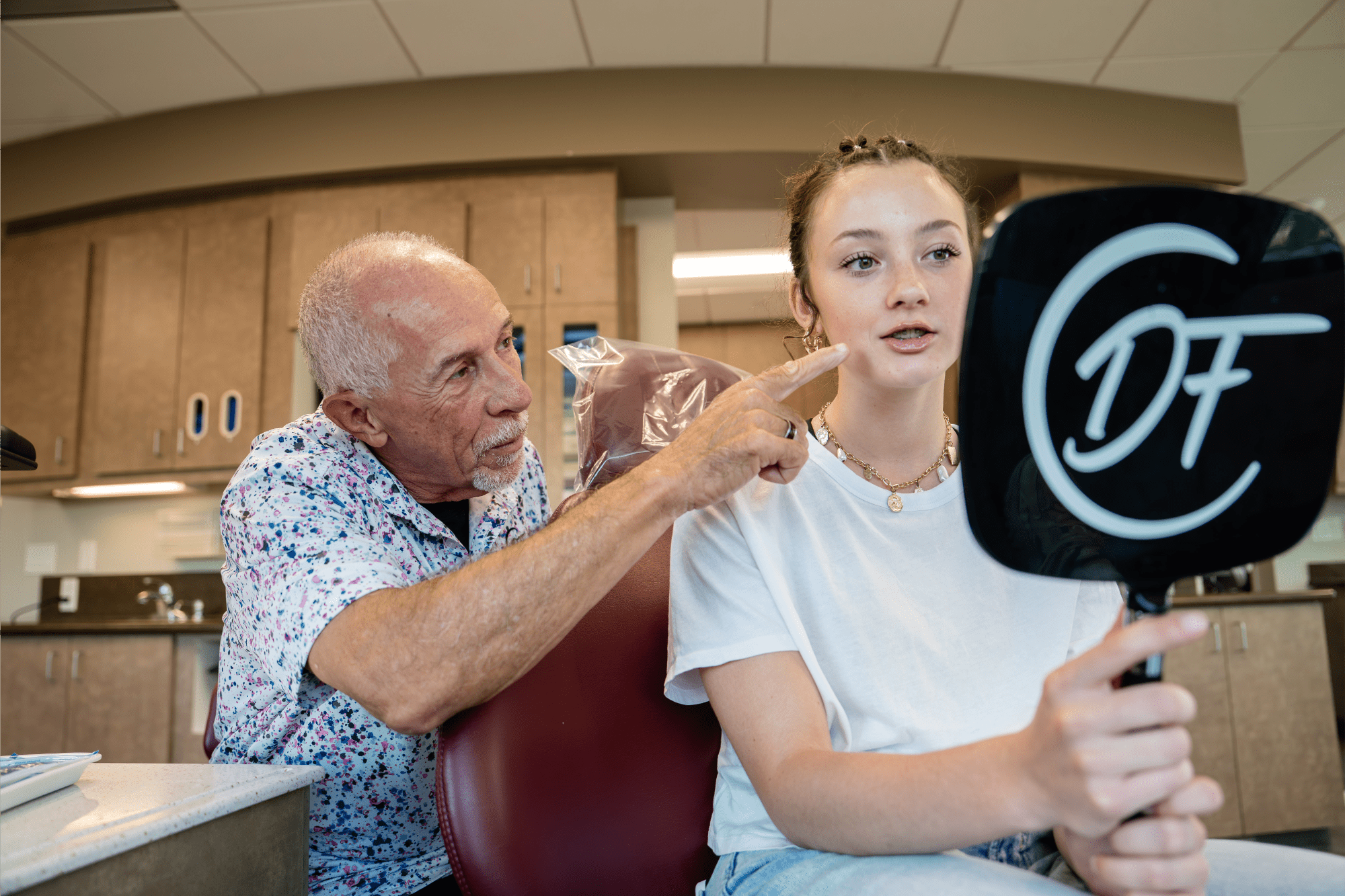 Teen patient looking at her metal braces during an orthodontic visit