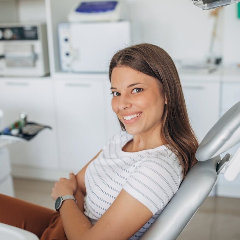 One woman, young lady sitting in dentist's chair.