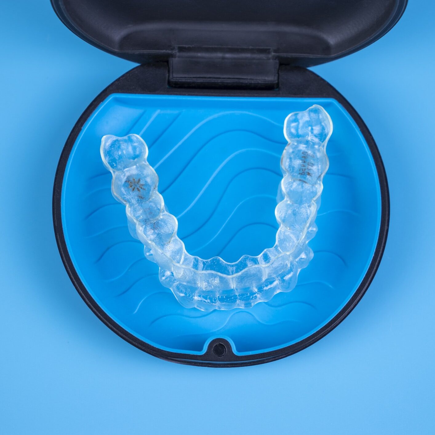 invisalign clear aligners resting inside of their carrying case