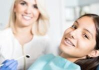 an orthodontic assistant inspecting a young girls braces