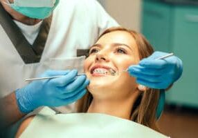 a woman getting her braces checked by her orthodontist